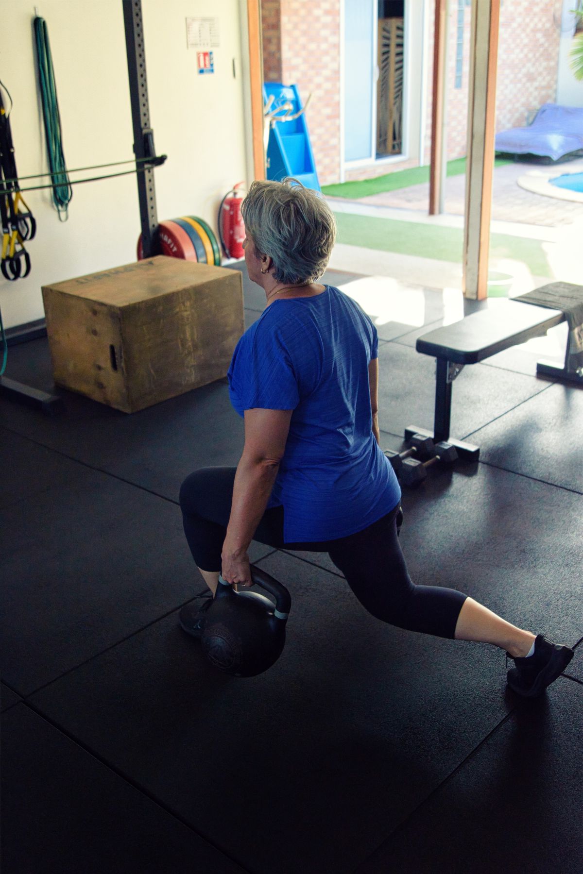 Cliente réalisant une fente avec kettlebell dans la salle Mind&Body